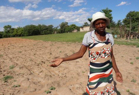 Photo shows a farmer in a barren field